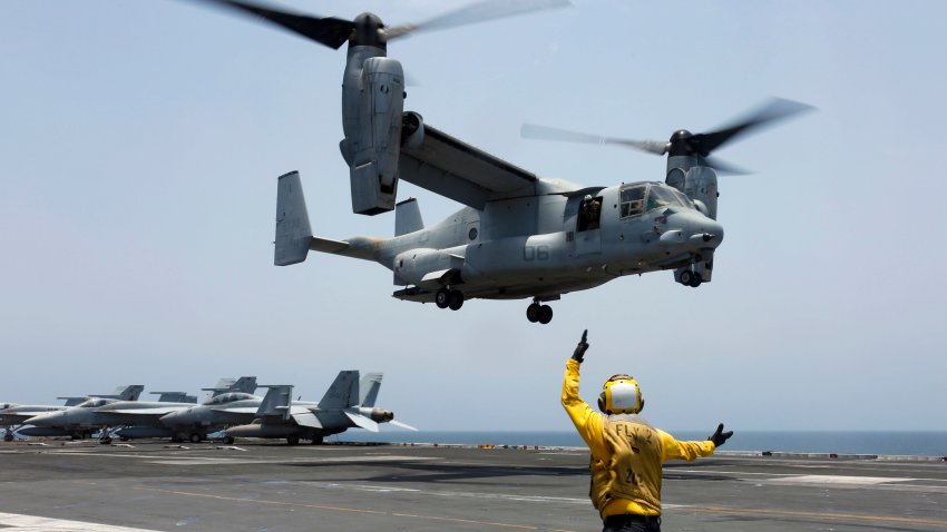 In this image provided by the U.S. Navy, Aviation Boatswain’s Mate 2nd Class Nicholas Hawkins signals an MV-22 Osprey to land on the flight deck of the USS Abraham Lincoln in the Arabian Sea on May 17, 2019.