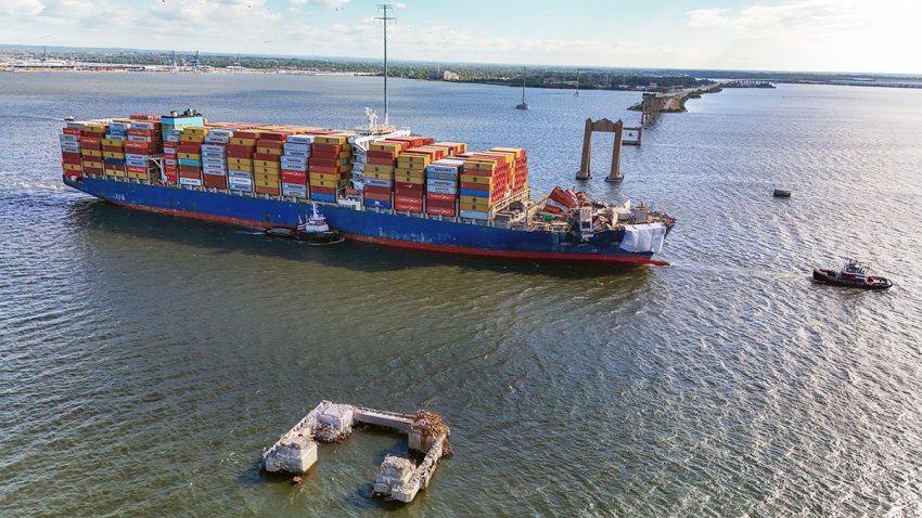 The container ship Dali is escorted through the Francis Scott Key Bridge collapse site on its way to Norfolk on June, 24, 2024.